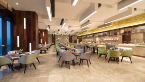 un restaurante con mesas y sillas y un bar en Holiday Inn Suzhou Taihu Lake, an IHG Hotel en Suzhou