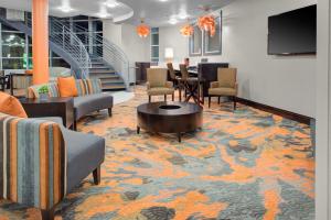 a lobby with chairs and a table and a television at Holiday Inn Windsor - Wine Country by IHG in Windsor
