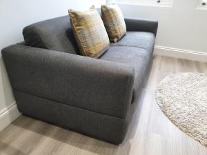 a gray couch with two pillows on it in a living room at 2-bed Notting Hill / Portobello in London