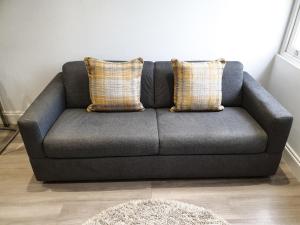 a gray couch with two pillows in a living room at 2-bed Notting Hill / Portobello in London