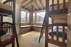 a bedroom with two bunk beds and a window at Dragonfly Chalet in Dinner Plain