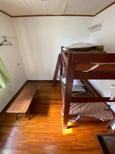 a room with two bunk beds and a wooden floor at Guesthouse Base Okinawa in Naha