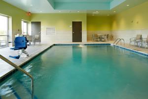 una piscina con una silla azul en una habitación en Holiday Inn Express & Suites - Cincinnati North - Liberty Way, an IHG Hotel en West Chester