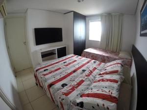 a bedroom with two beds and a flat screen tv at Vista deslumbrante para o mar em Ponta N in Natal