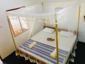 łóżko z baldachimem w pokoju w obiekcie Beach Wave Hotel w mieście Arugam Bay