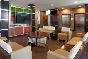 a living room with a tv and a table and chairs at The Holiday Inn Amarillo West Medical Center, an IHG Hotel in Amarillo