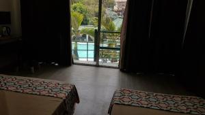 een kamer met 2 bedden en uitzicht op een zwembad bij V Resort Dasma in Dasmariñas
