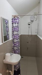 a bathroom with a sink and a shower curtain at V Resort Dasma in Dasmariñas