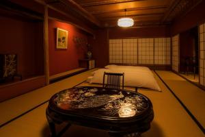 a room with a bed and a table in it at Yamanoo in Kanazawa