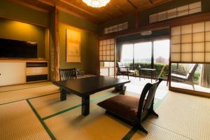 uma sala de jantar com uma mesa e cadeiras num quarto em Yamanoo em Kanazawa