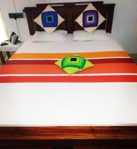 波隆納魯沃的住宿－ARANI HOMESTAY，床上有红色和黄色的毯子