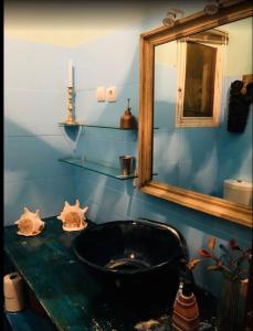 a bathroom with a black sink and a mirror at Guesthouse MALAGUETA INN I & II in Maputo