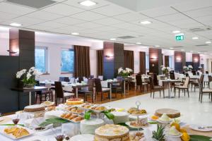una stanza con tavoli e sedie con sopra del cibo di Holiday Inn Salerno-Cava De' Tirreni, an IHG Hotel a Cava deʼ Tirreni