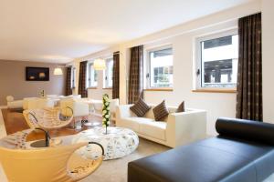 a living room with white furniture and windows at Holiday Inn Salerno-Cava De' Tirreni by IHG in Cava deʼ Tirreni