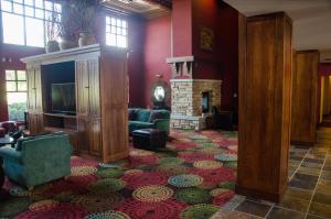 a living room with a fireplace and a television at Holiday Inn Hotel Pewaukee-Milwaukee West by IHG in Pewaukee