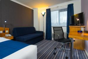 a hotel room with a bed and a desk and a chair at Holiday Inn Express Manchester East, an IHG Hotel in Manchester