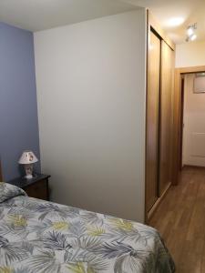 - une chambre avec un lit et une lampe sur une table dans l'établissement Apartamentos Chevere Azul, à Oviedo