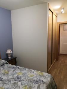 1 dormitorio con 1 cama y 1 lámpara en una mesa en Apartamentos Chevere Azul, en Oviedo