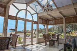 a conservatory with a table and chairs and a chandelier at Lagoon Loge in Walvis Bay