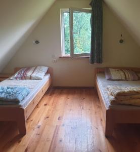 two beds in a room with a window at Domek całoroczny El Coyote in Hoczew