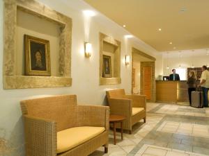 una sala de espera con sillas y un mostrador en IDINGSHOF Hotel & Restaurant, en Bramsche