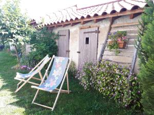 two chairs sitting in the grass in front of a house at L'Orme-Vial in Saint-Galmier