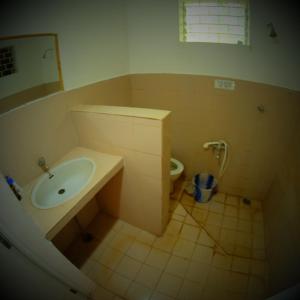 a bathroom with a sink and a toilet at New Creation Guest House in Auroville