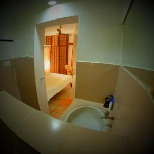 a view of a bathroom with a toilet and a bedroom at New Creation Guest House in Auroville