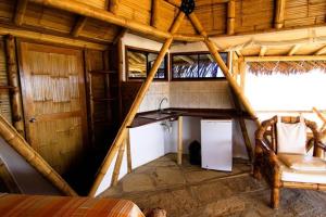 a small room with a kitchen and a table in a house at Oceanic Bungalows in Los Órganos