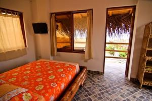 a bedroom with a bed and a large window at Oceanic Bungalows in Los Órganos