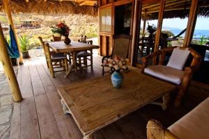 a living room with a table and chairs and a table sidx sidx sidx at Oceanic Bungalows in Los Órganos