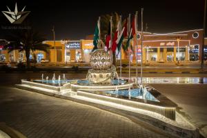 a fountain in the middle of a street at night at Seven Palaces in Hafr Al-Batin