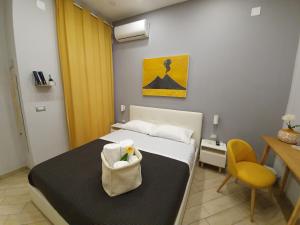a bedroom with a bed and a table and a yellow chair at Solfatara Suites B&B in Pozzuoli