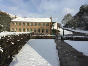 a brick building with snow on the ground in front at Gradbach Mill B&B in Buxton