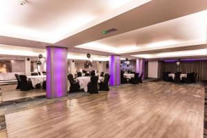 a banquet hall with tables and chairs and purple curtains at Holiday Inn Newcastle-Jesmond by IHG in Newcastle upon Tyne