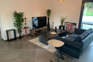 VILLA BENOA في اوليتا: غرفة معيشة مع أريكة زرقاء وتلفزيون