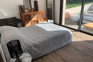 a bedroom with a large bed and a balcony at VILLA BENOA in Oletta