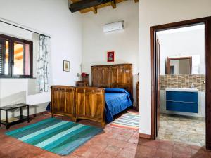 ein Schlafzimmer mit einem Bett und einer Tür zu einem Bad in der Unterkunft Fontana del Cherubino in Santa Maria di Licodia