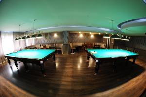 2 biljarttafels in een kamer met een bar bij Hotel Intourist in Mukacheve