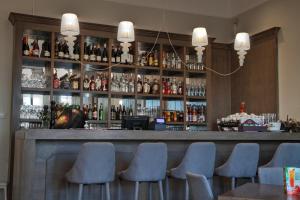 a bar with blue chairs and bottles of alcohol at Zespół Pałacowo-Parkowy Bądzów in Polkowice