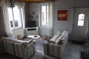 uma sala de estar com dois sofás e uma mesa em Gîte Des Sapins em Ranchal