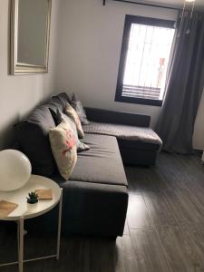 sala de estar con sofá y ventana en Apartamento Amapola en Ardales