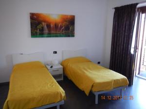 a room with two beds and a painting on the wall at Affittacamere Derby in Ranica