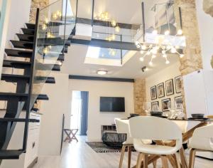 a dining room with a staircase and a dining table with white chairs at LUXURY New Loft CITY CENTRE & Castle, Alicante in Alicante