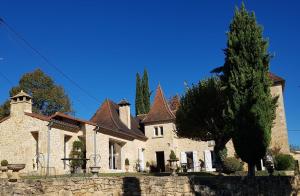 萨尔拉拉卡内达Au Clos de Mathilde的一座大石头房子,前面有一棵树