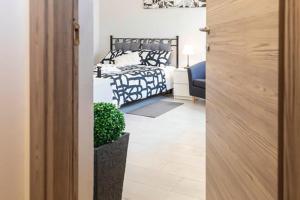 Un dormitorio con una cama y una planta en una habitación en La Casina di Mira, en Montepulciano