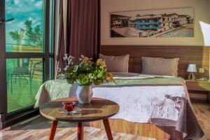 a bedroom with a bed with a vase of flowers on a table at Hotel Grand View in Tbilisi in Tbilisi City