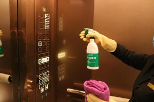 a person wearing a glove holding a bottle of soda at Rongjiang Hotel in Jieyang