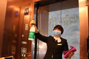 a person in a mask is holding a bottle of bleach at Rongjiang Hotel in Jieyang