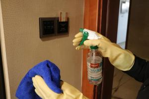 a person in yellow gloves holding a bottle of paint at Rongjiang Hotel in Jieyang
